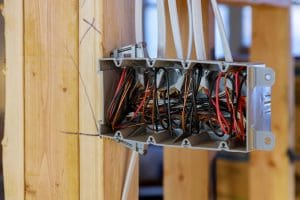Interior view of a electrical box with wiring in a wooden beams new home under construction